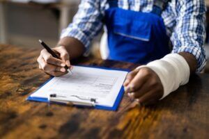 A man is filling out a workers’ compensation claim document. What documents do I need to file a workers’ compensation claim?