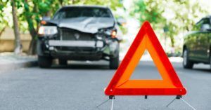 warning triangle set up in road in front of crashed car