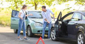un hombre y una mujer discuten sobre quién tiene la culpa de un accidente de carro