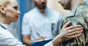 male soldier being consoled by female doctor and male nurse