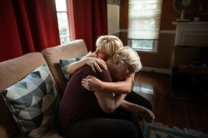 An elderly woman being hugged