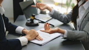 Woman Client Consulting a Lawyer with Laptop and Tablet at Office