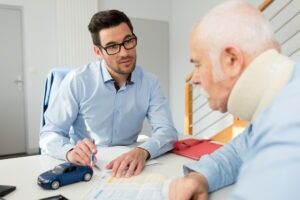 Personal injury lawyer in meeting with client wearing neck brace