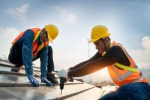Construction workers on a roof. Find out how to get compensation with a Southern Pines construction accident lawyer.