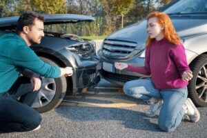 Two motorists talk to each other after their vehicles are involved in a crash. If you have been in a car accident, avoid admitting fault. Anything you say can be used against you from the opposing party. Contact a lawyer after the crash to review your legal options.