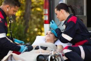 First responders attend to a car accident victim and look for the symptoms of shock after a car accident.