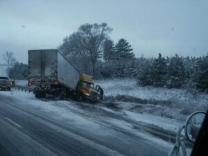 A semi-truck is stuck on the side of the road after one of the causes of jackknife truck accidents occurred.