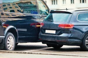 Two cars after a parking lot accident, with the owners wondering who is at fault