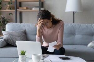 A woman reviews a medical bill after a North Carolina car accident. Lost wage payments depend on who caused the crash and the insurance coverage involved.